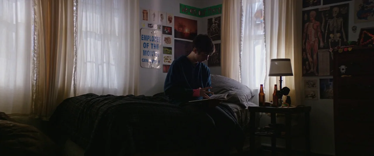 Super Dark Times (2017) movie still: medium — A cluttered teen bedroom with posters on the walls and dual windows covered by curtains. The young man…