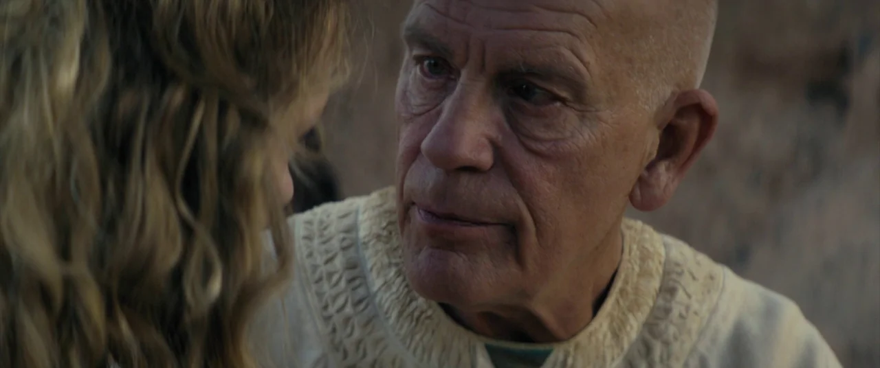 Seneca: On The Creation Of Earthquakes (2023) movie still: closeup — An arid, sun-bleached outdoor environment provides a stark, muted background…