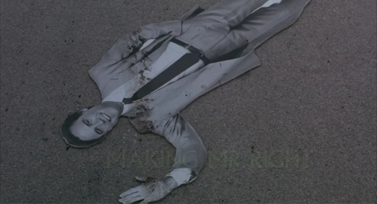 Making Mr. Right (1987) movie still: fullbody — A flat cardboard cutout of a smiling man lies on grey pavement. The image of the man is distorted by…
