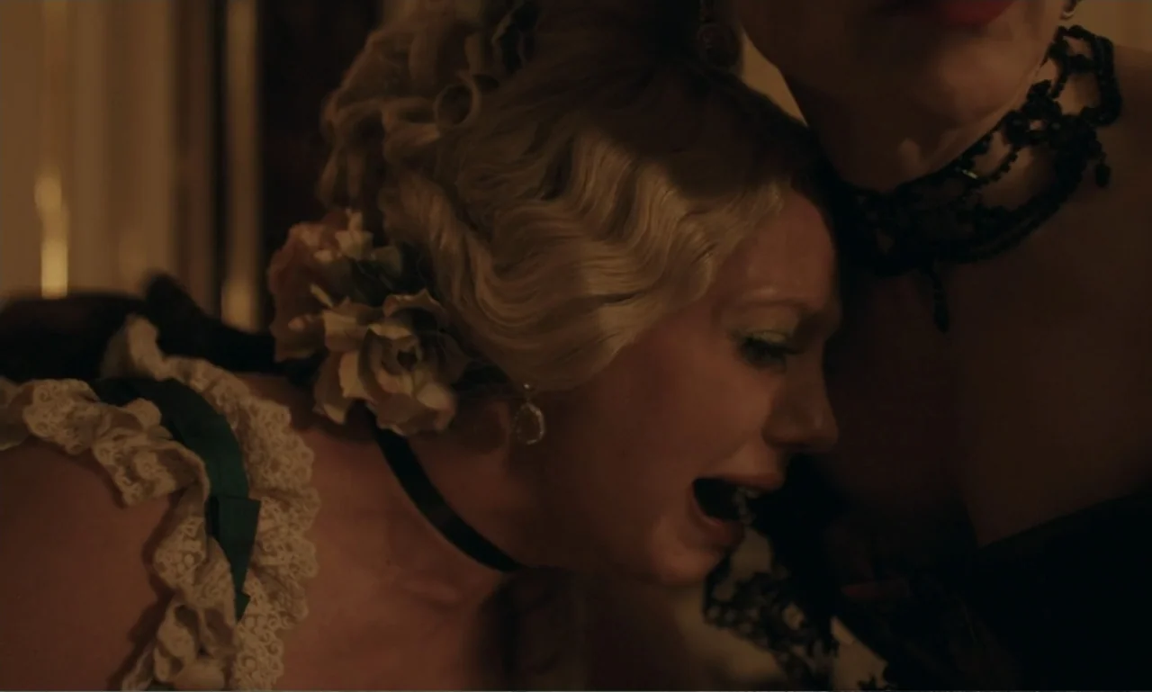 The Ugly Stepsister (2025) movie still: closeup — A dimly lit room with period-appropriate Victorian or 1920s decor details. One woman cries against…