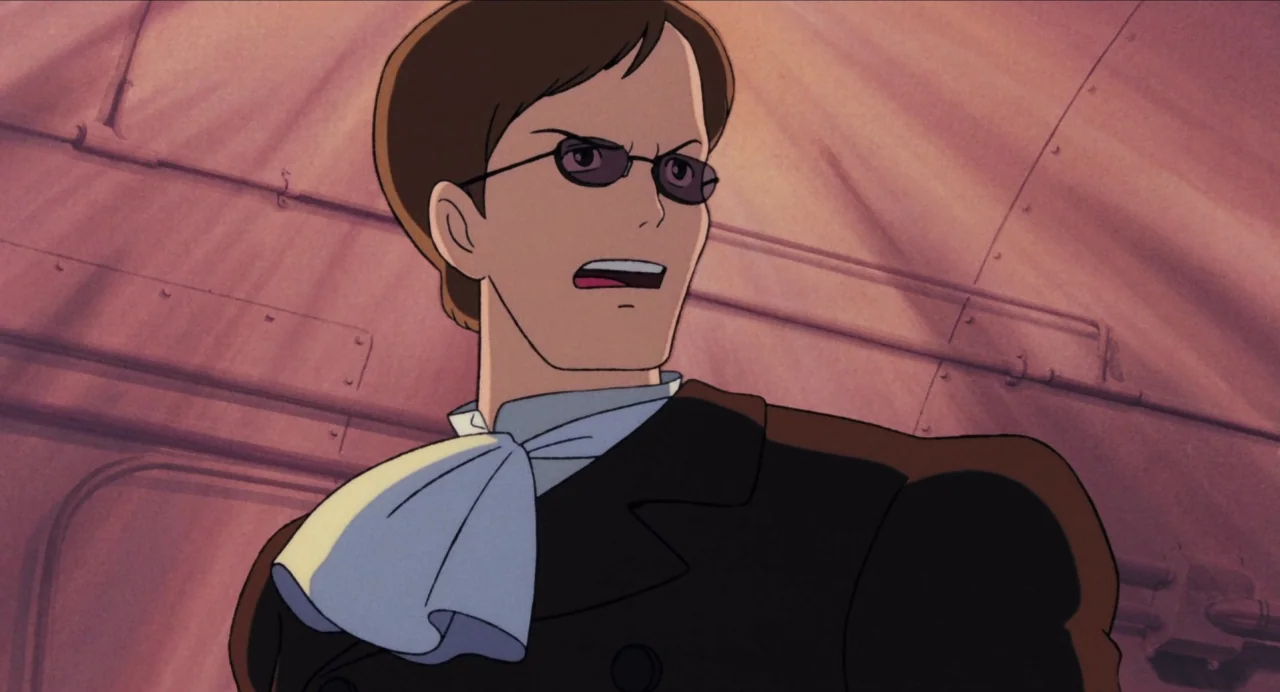 Castle in the Sky (1986) movie still: medium — A metal airship interior with riveted walls panels in a muted pink tone. A man with short brown hair…