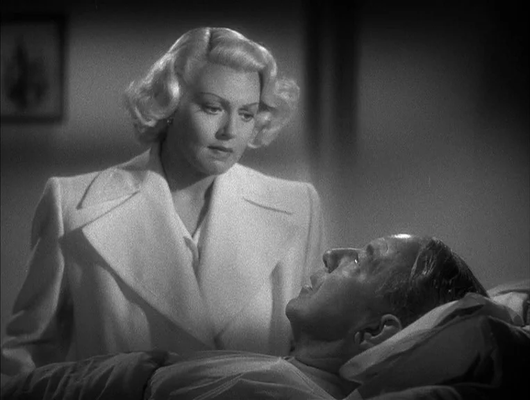 The Postman Always Rings Twice (1946) movie still: medium — A dimly lit room with a man lying in a hospital bed. A woman in a white jacket stands…