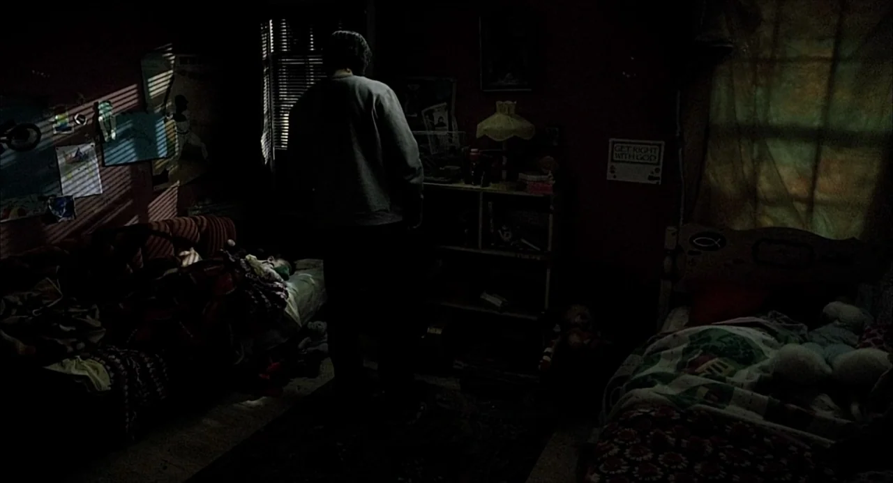 21 Grams (2003) movie still: medium — A cluttered child's room features two beds and a shelving unit in deep shadow. A man stands in the center of…