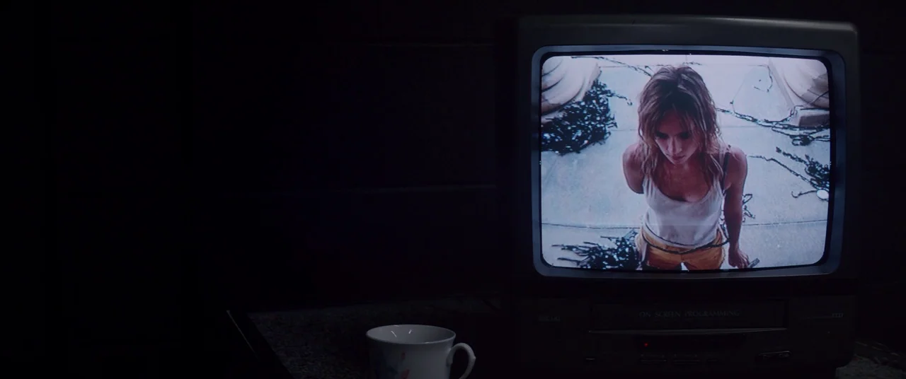 The Bad Batch (2016) movie still: wide — A dark, empty room contains a small CRT television set and a porcelain teacup. The television screen…