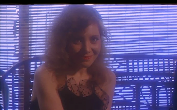 Pepi, Luci, Bom and Other Girls Like Mom (1980) movie still: medium — A woman sits in a chair in front of a window with horizontal blinds. The room…