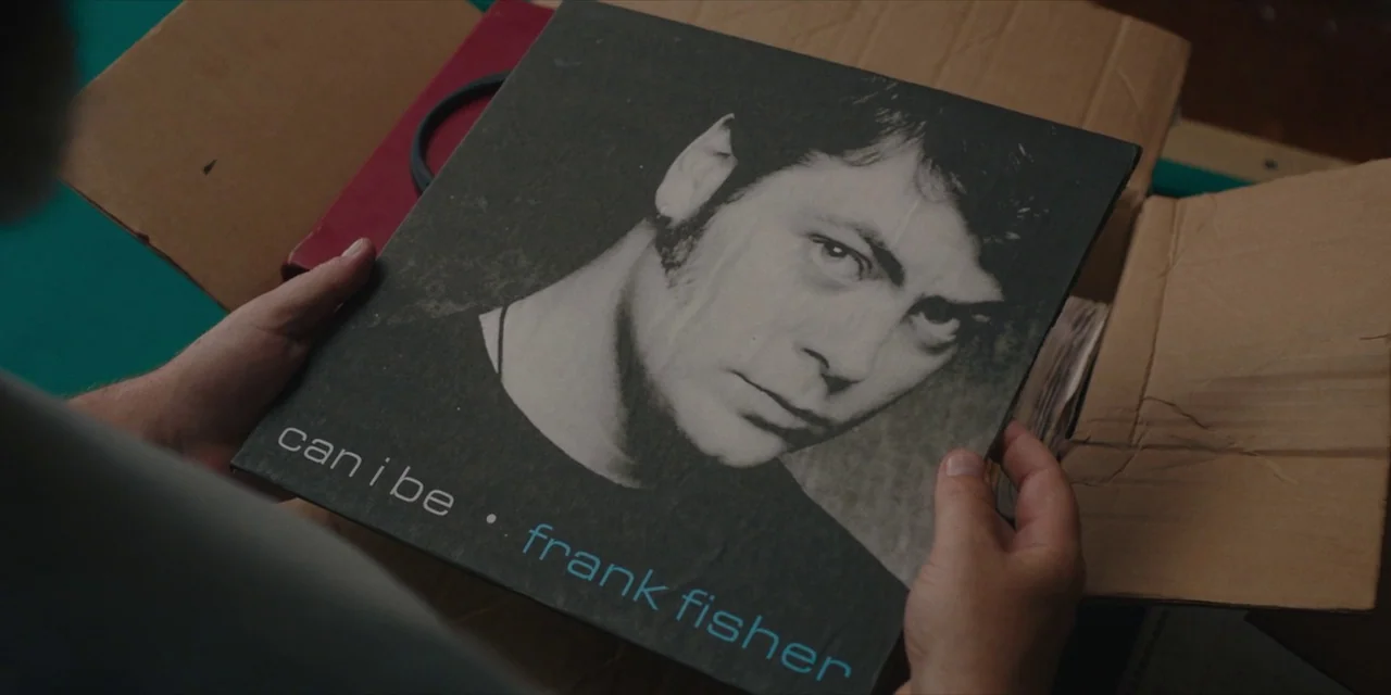 Hearts Beat Loud (2018) movie still: closeup — A close-up view of hands holding a square black vinyl album cover. The record is labeled 'can i be'…