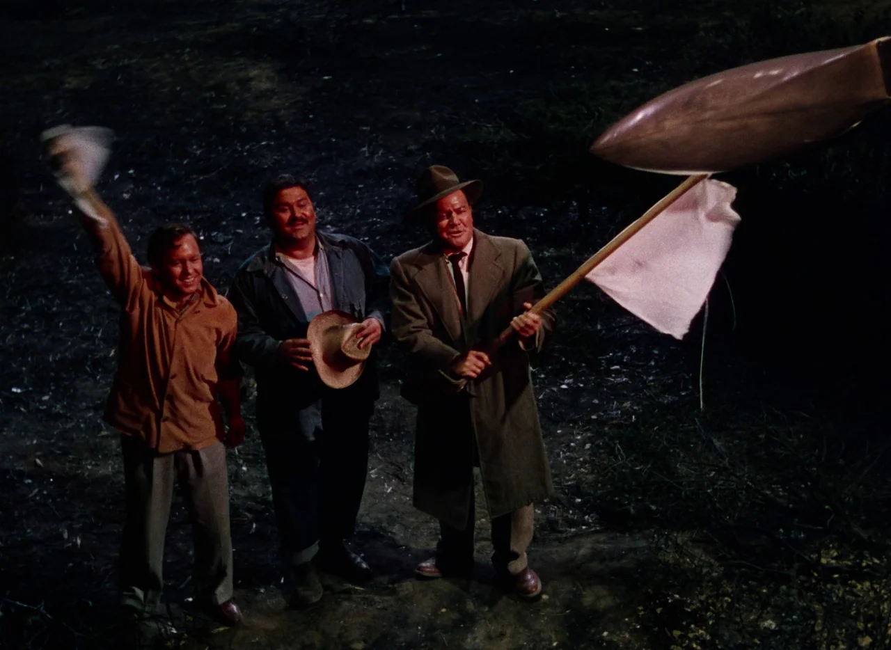 The War of the Worlds (1953) movie still: fullbody — Three men stand on dark, uneven dirt ground at night under artificial illumination. The man on…