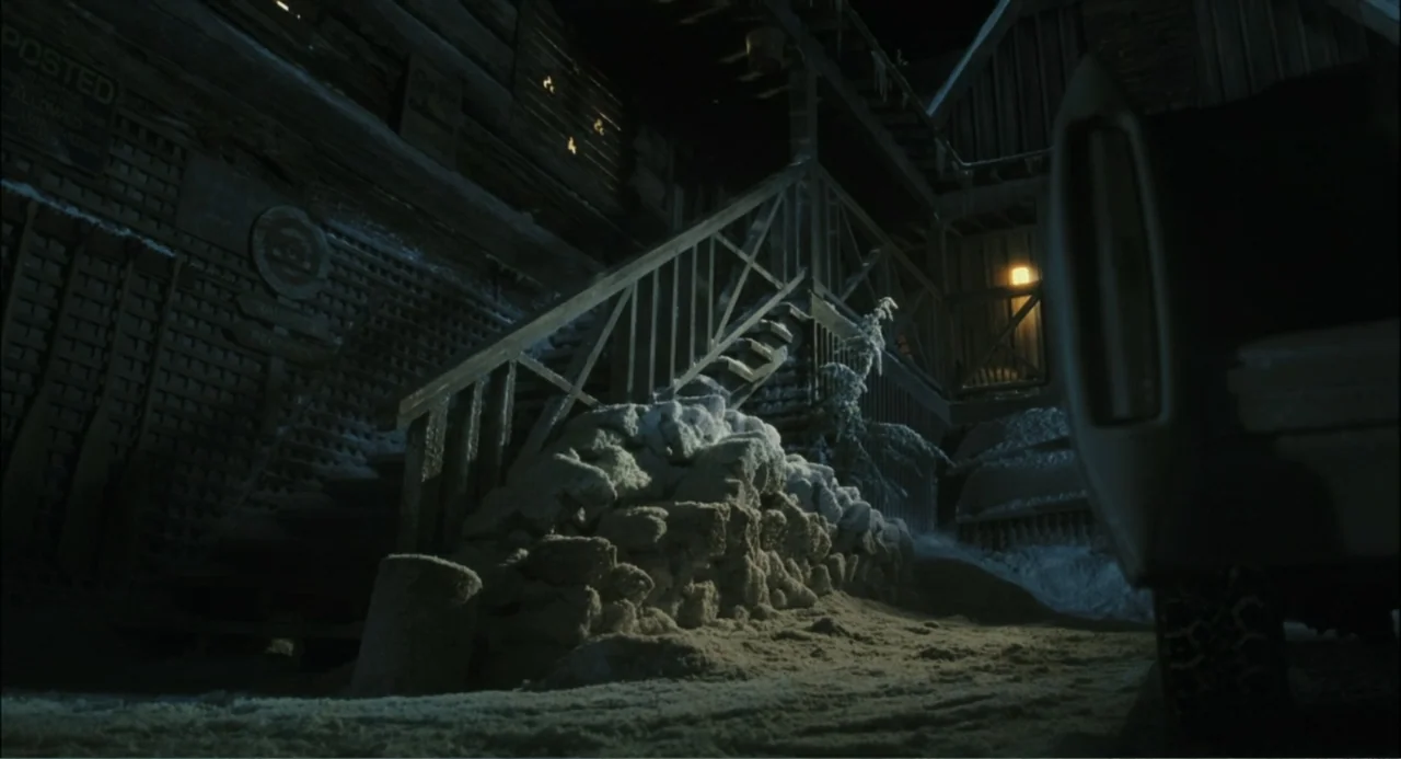 El hijo del diablo (1966) movie still: wide — A weathered wooden building stands at night covered in a layer of fresh snow. The exterior porch…