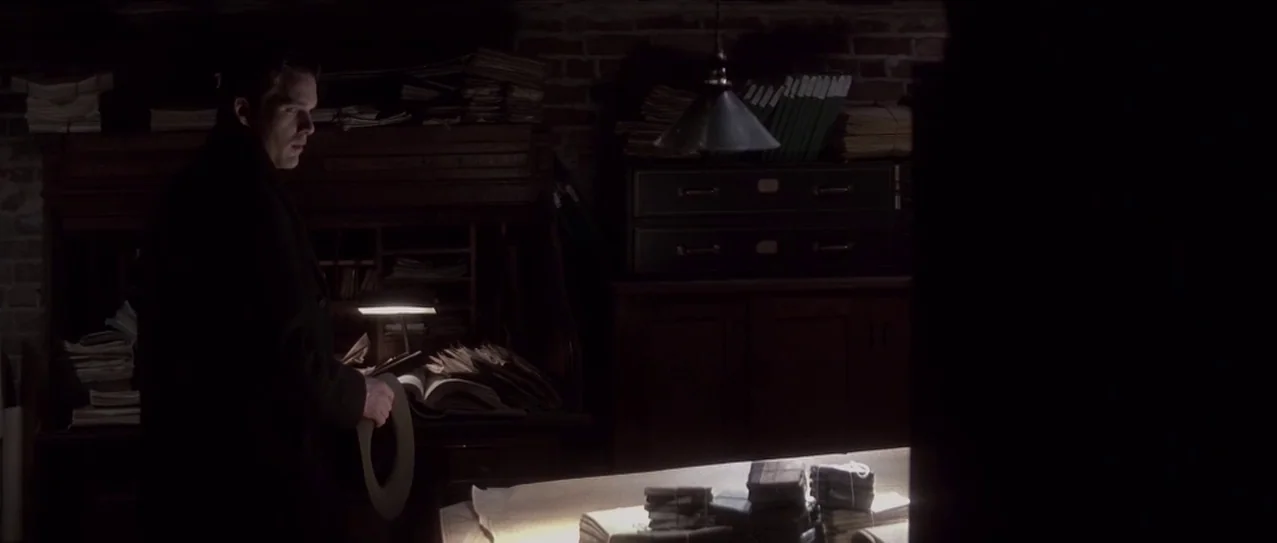 Snow Falling on Cedars (1999) movie still: medium — A dark, cluttered workspace contains stacked papers, a wooden desk, and metal filing cabinets. A…