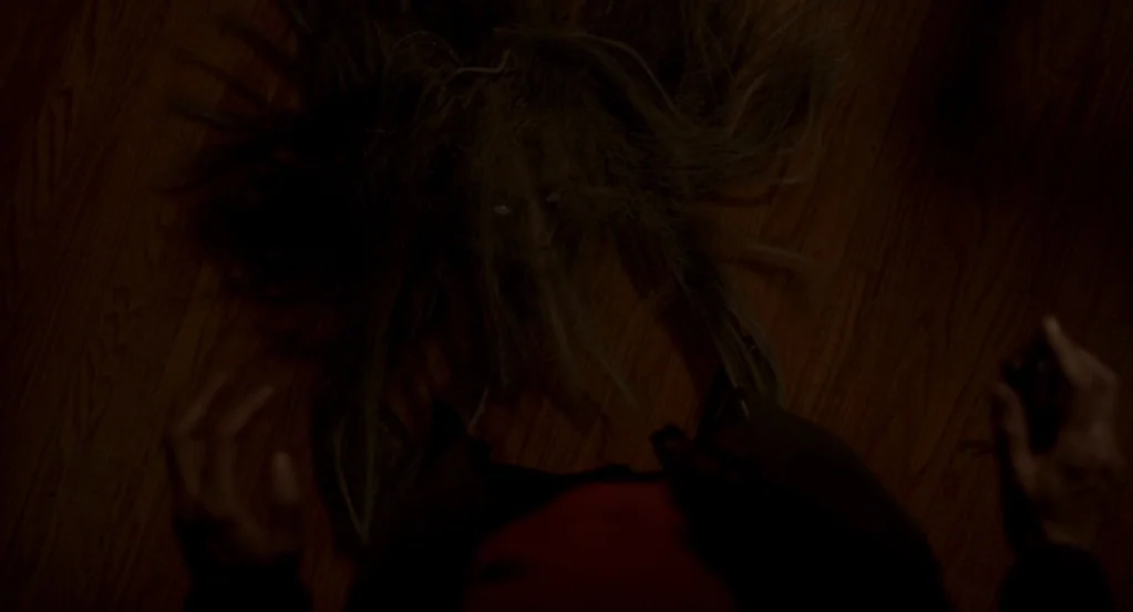 Mama (2013) movie still: medium — A person's point of view looks down at another lying on a dark wooden floor. The face is surrounded by long hair…