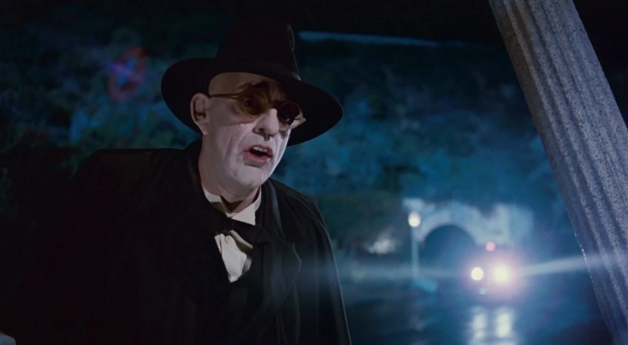 Who Framed Roger Rabbit (1988) movie still: medium — A dark night setting features a bridge illuminated by a distant vehicle's headlamps. An elderly…