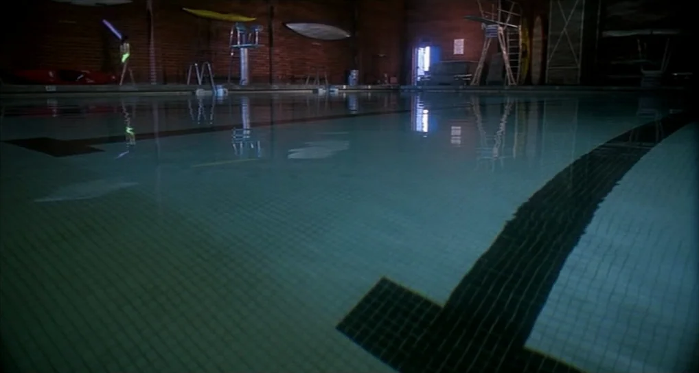 A Nightmare On Elm Street 5: The Dream Child (1989) movie still: establishing — An indoor pool facility features dark brick walls and reflective…