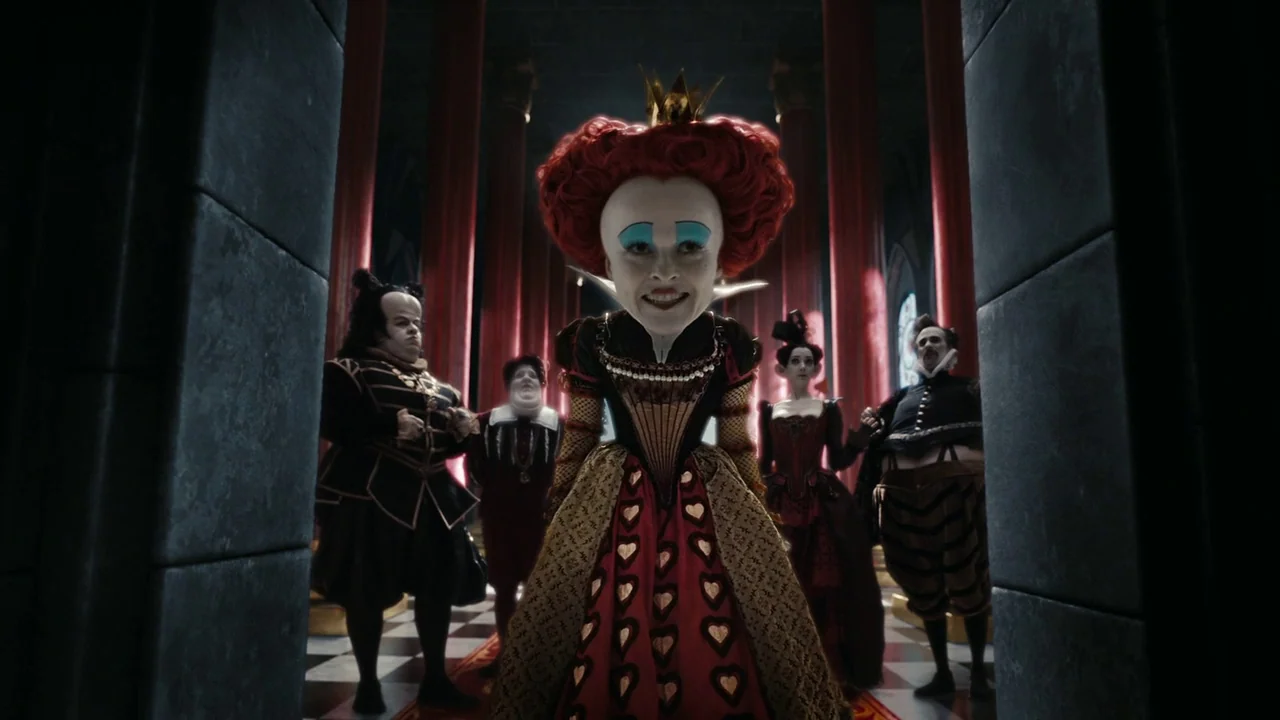 Alice in Wonderland (2010) movie still: fullbody — A stone hall with towering red pillars and a black and white tiled floor. A queen with an…