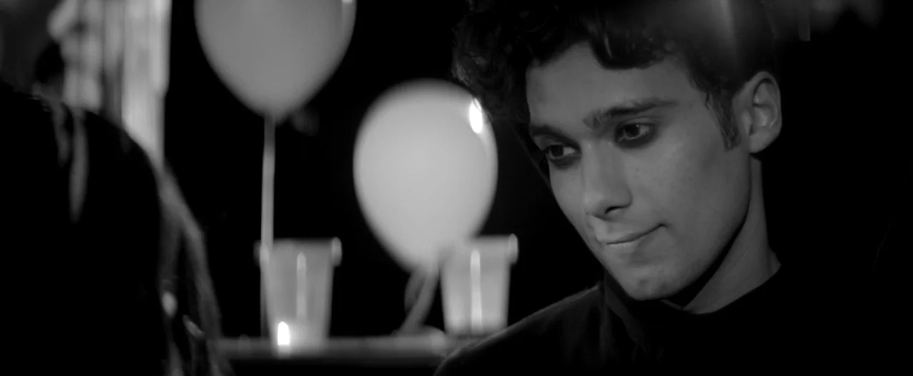 A Girl Walks Home Alone at Night (2014) movie still: closeup — An interior space features blurred white balloons and lit candles in the dark…