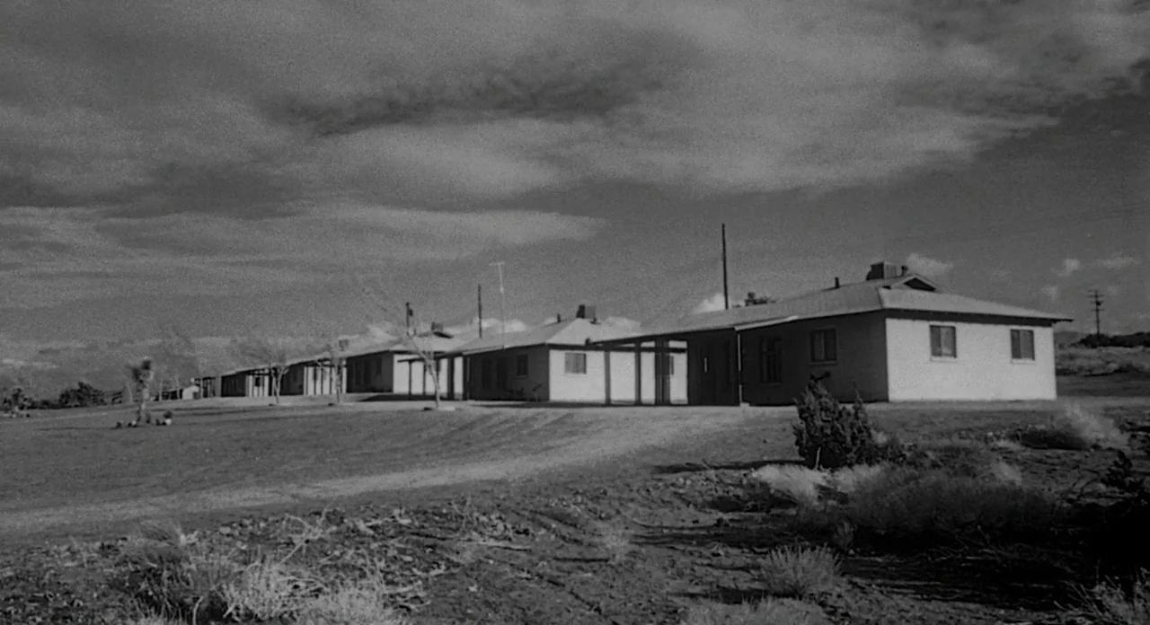 Touch of Evil (1958) movie still: establishing — A single-story 1950s roadside motel complex stretches across a dry, sparsely vegetated landscape.…