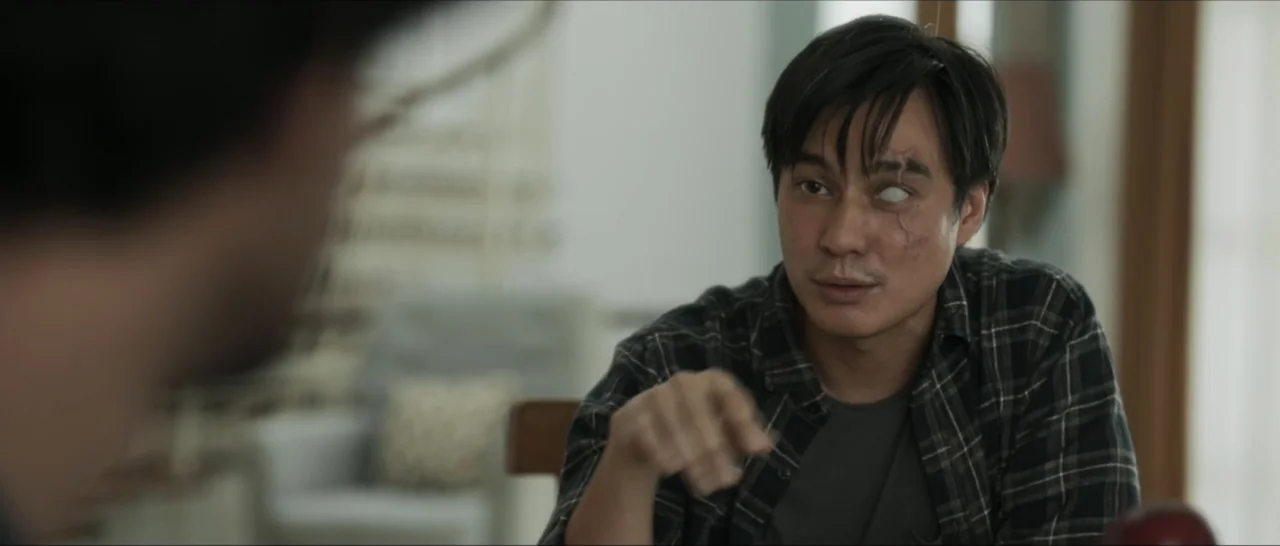 Innocent Vengeance (2023) movie still: medium — An interior dining area with a soft-focus background featuring a chair. An adult male with a facial…