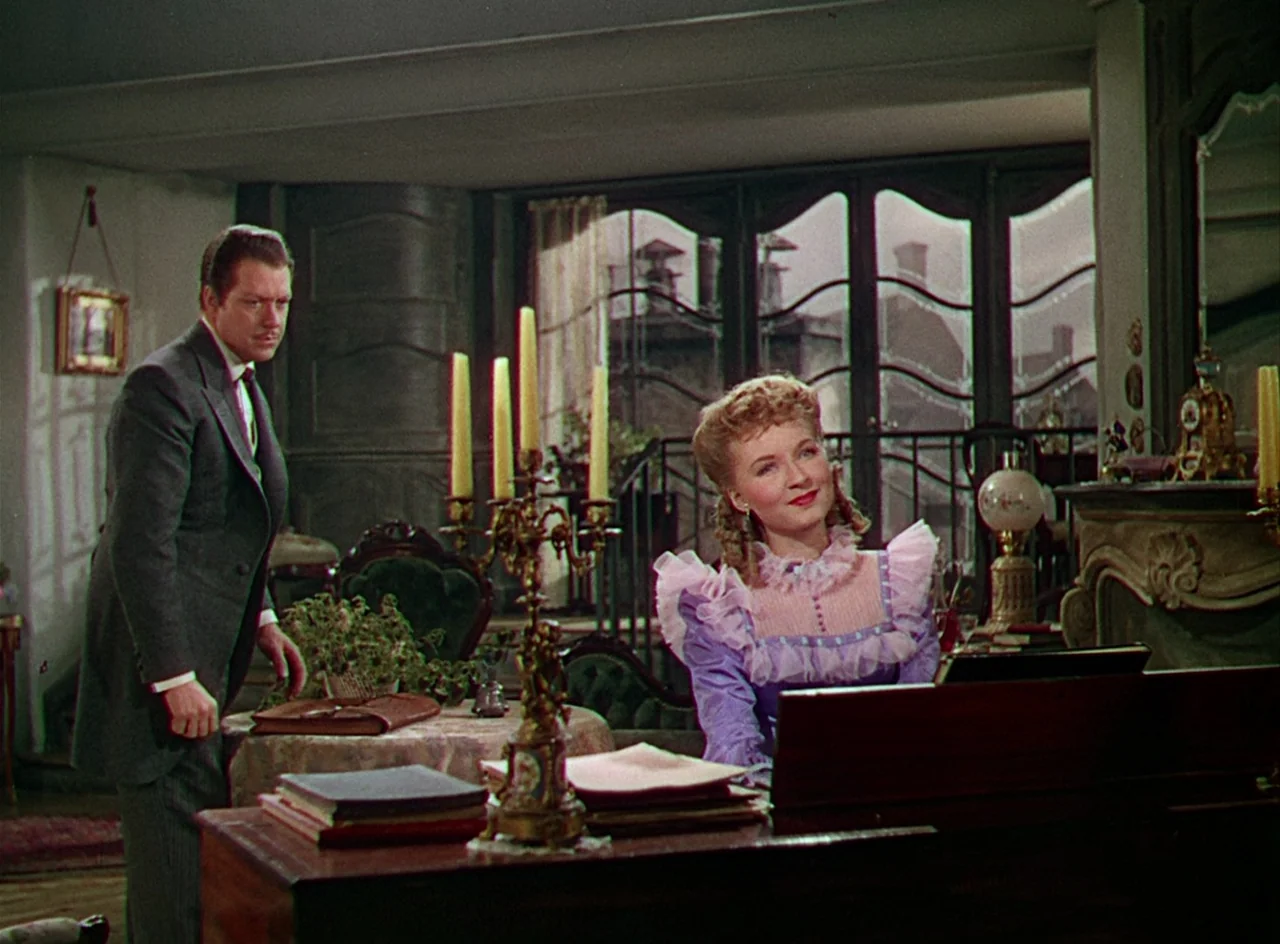 Phantom of the Opera (1943) movie still: medium — An ornate parlor featuring a piano and large window with decorative wrought iron details. A man in…