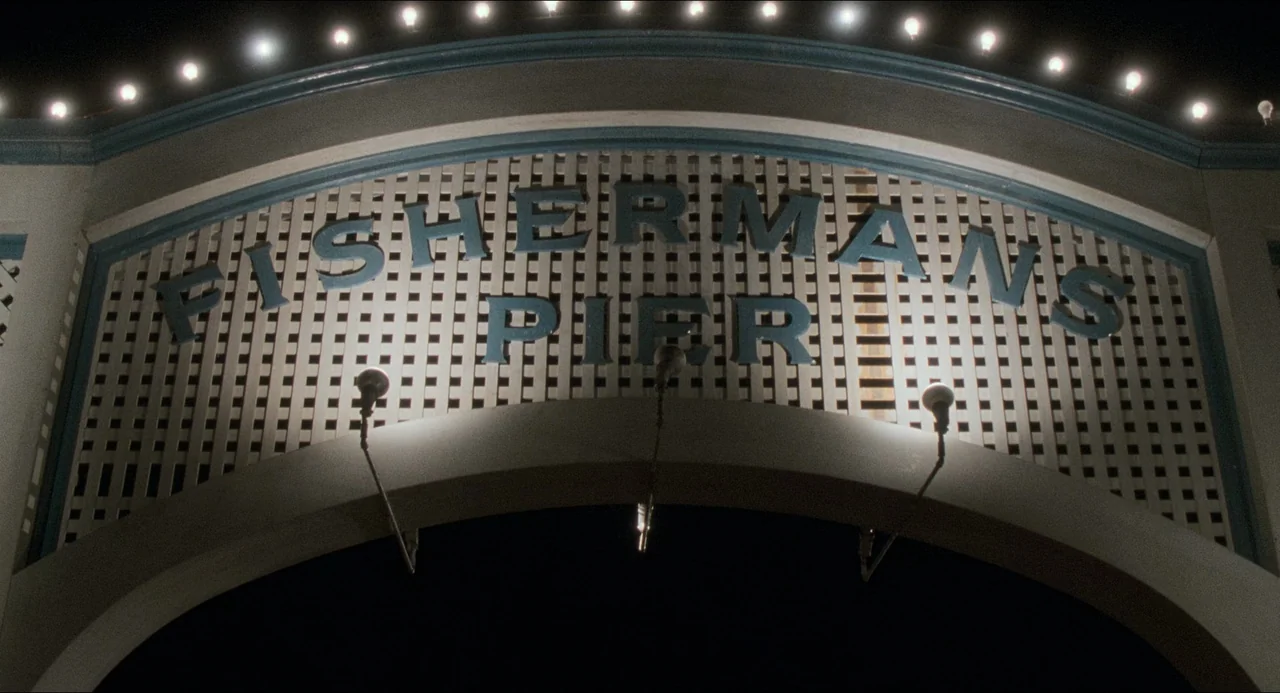 Devil In A Blue Dress (1995) movie still: establishing — A wooden lattice archway features large blue lettering spelling out Fisherman's Pier at…