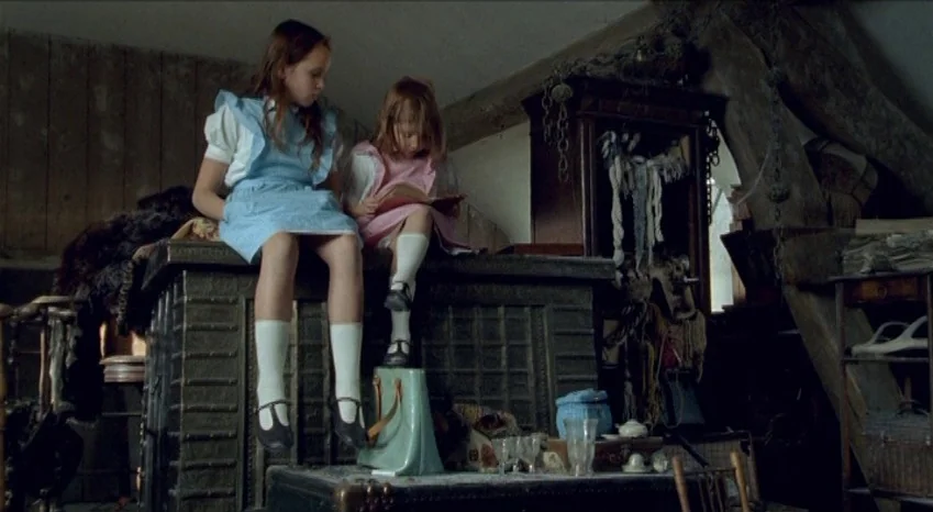 Bluebeard (2009) movie still: medium — An attic filled with old wooden furniture, assorted trinkets, and exposed wooden structural beams. Two young…