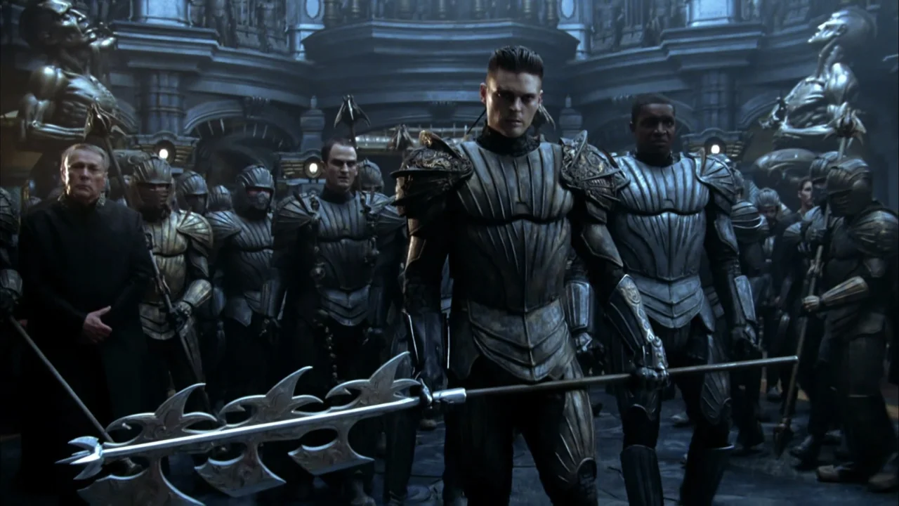 The Chronicles of Riddick (2004) movie still: medium — A stone chamber features elaborate architectural carvings and gold-toned statues along the…