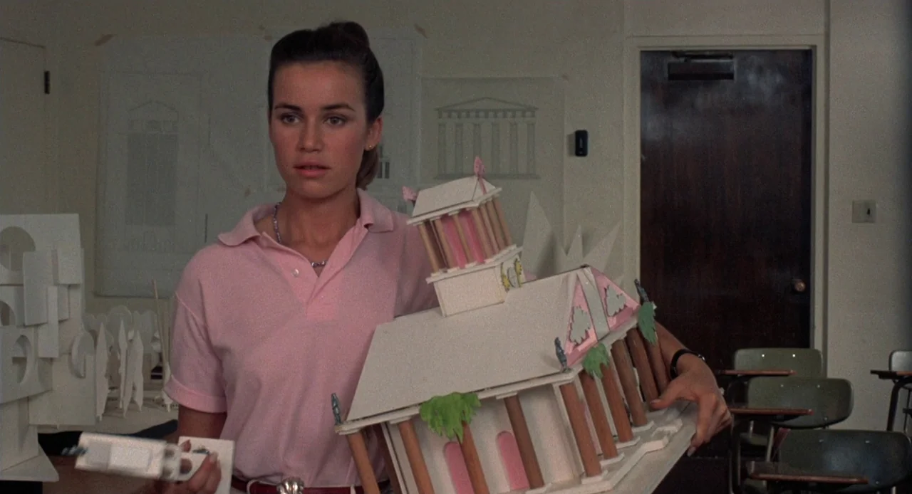 Breathless (1983) movie still: medium — An academic room contains white architectural sketches pinned to the wall behind a student. A young woman…