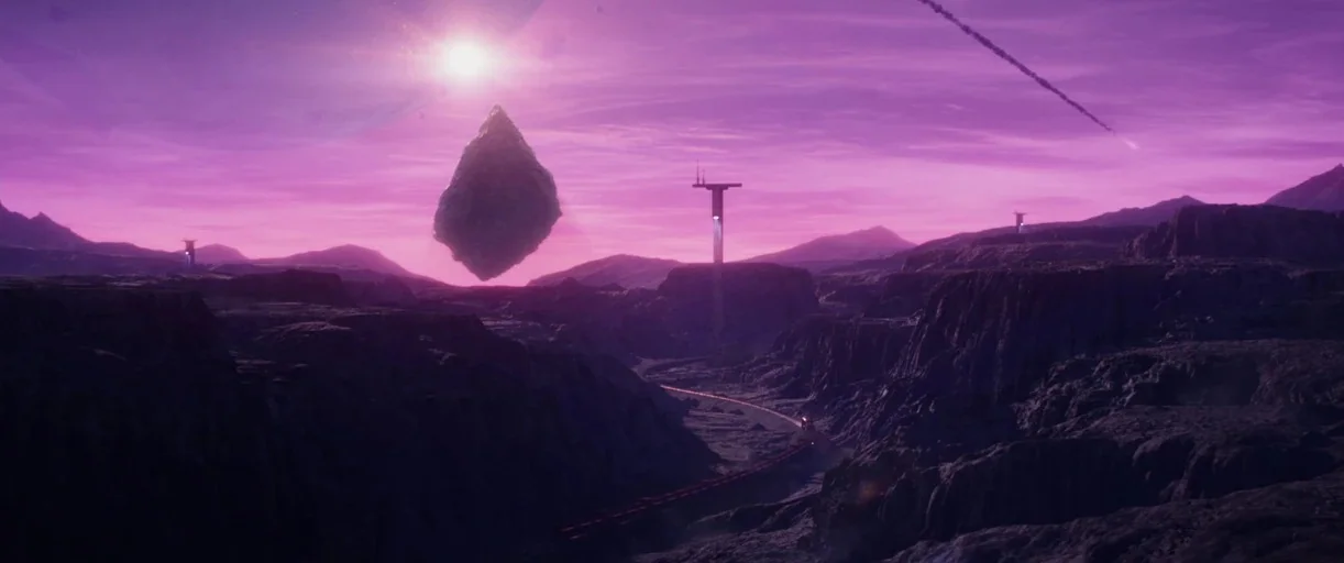 Loki (2021) movie still: establishing — A desolate rocky alien planet landscape features a floating dark rock formation. Distant towers rise from…