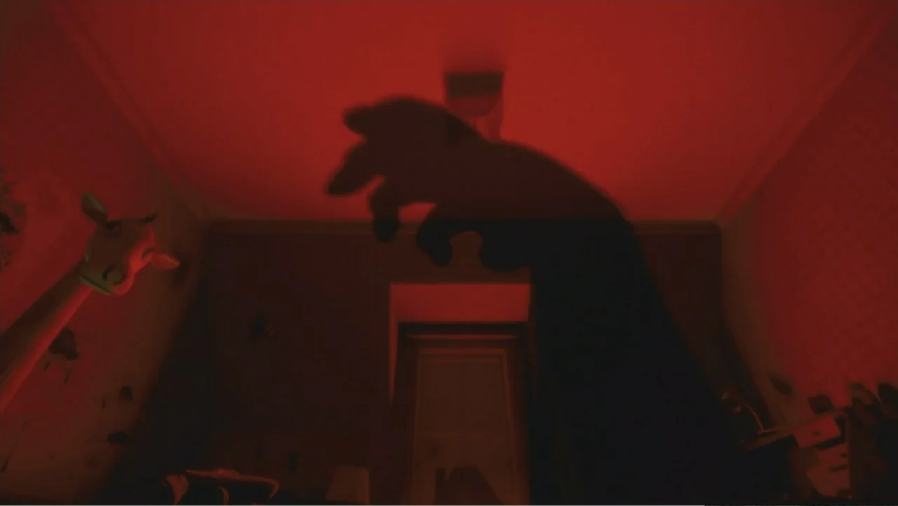 Monster House (2006) movie still: wide — A dark nursery room interior features a bright red light illuminating the ceiling. A giant shadow of a hand…