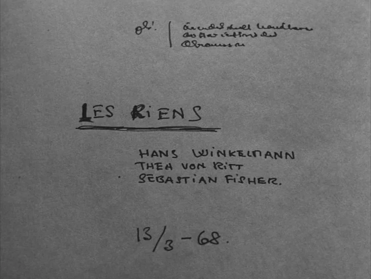 The Rite (1969) movie still: closeup — A piece of textured gray paper features handwritten ink text and numbers. The document lists names and a date…
