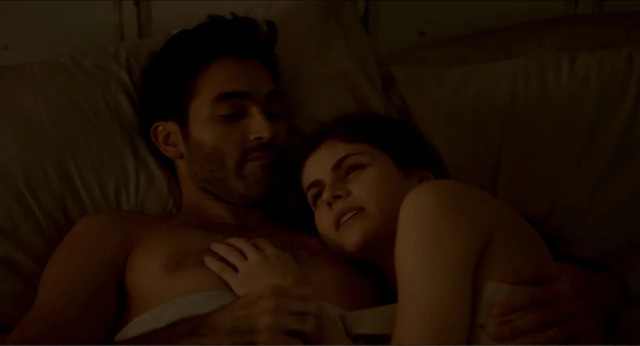 Can You Keep a Secret? (2019) movie still: medium — An interior bedroom at night with soft lighting highlighting the two subjects in bed. A man and…