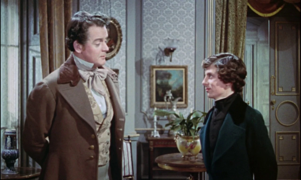 The Curse of Frankenstein (1957) movie still: medium — A refined interior with patterned wallpaper and antique paintings decorating the walls. An…