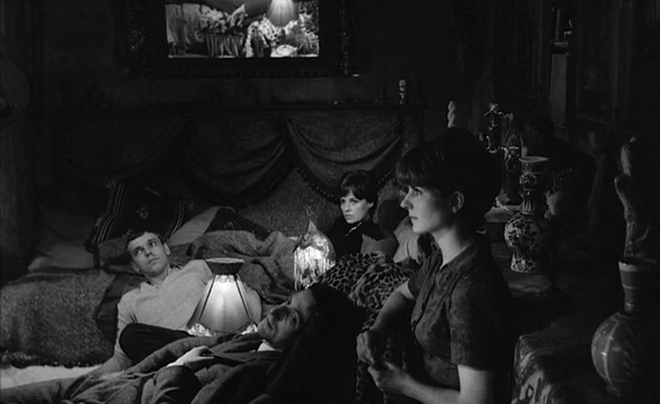 Le Feu Follet (1963) movie still: medium — A dimly lit room filled with textured fabrics and decorative objects in the 1960s. Four people sit…