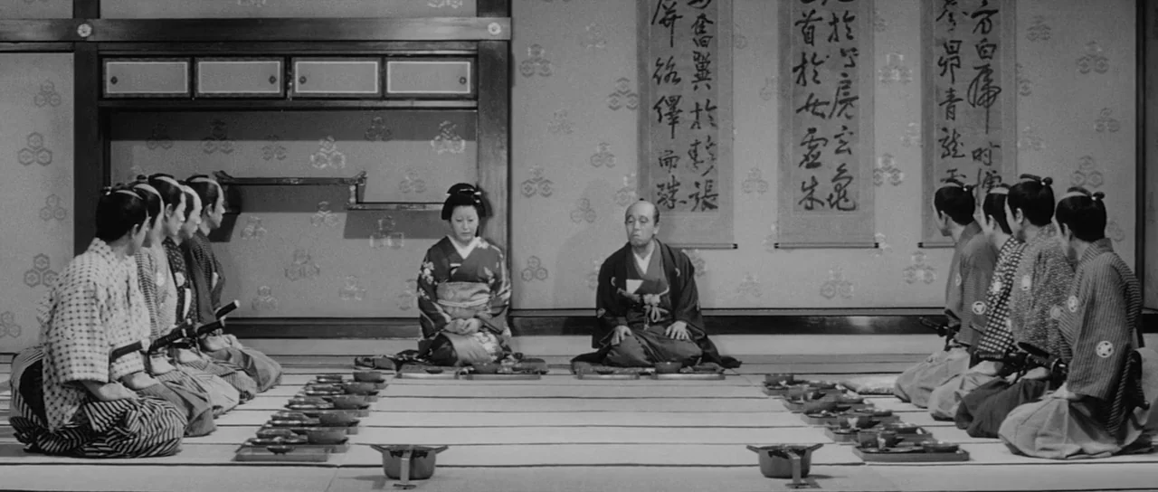 Sanjuro (1962) movie still: wide — A traditional Japanese room features tatami flooring and paper walls with calligraphic scrolls hung. Twelve…