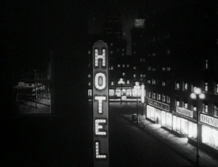 Dementia (Daughter of Horror) (1955) movie still: establishing — An empty city street is illuminated by a prominent vertical neon hotel sign.…