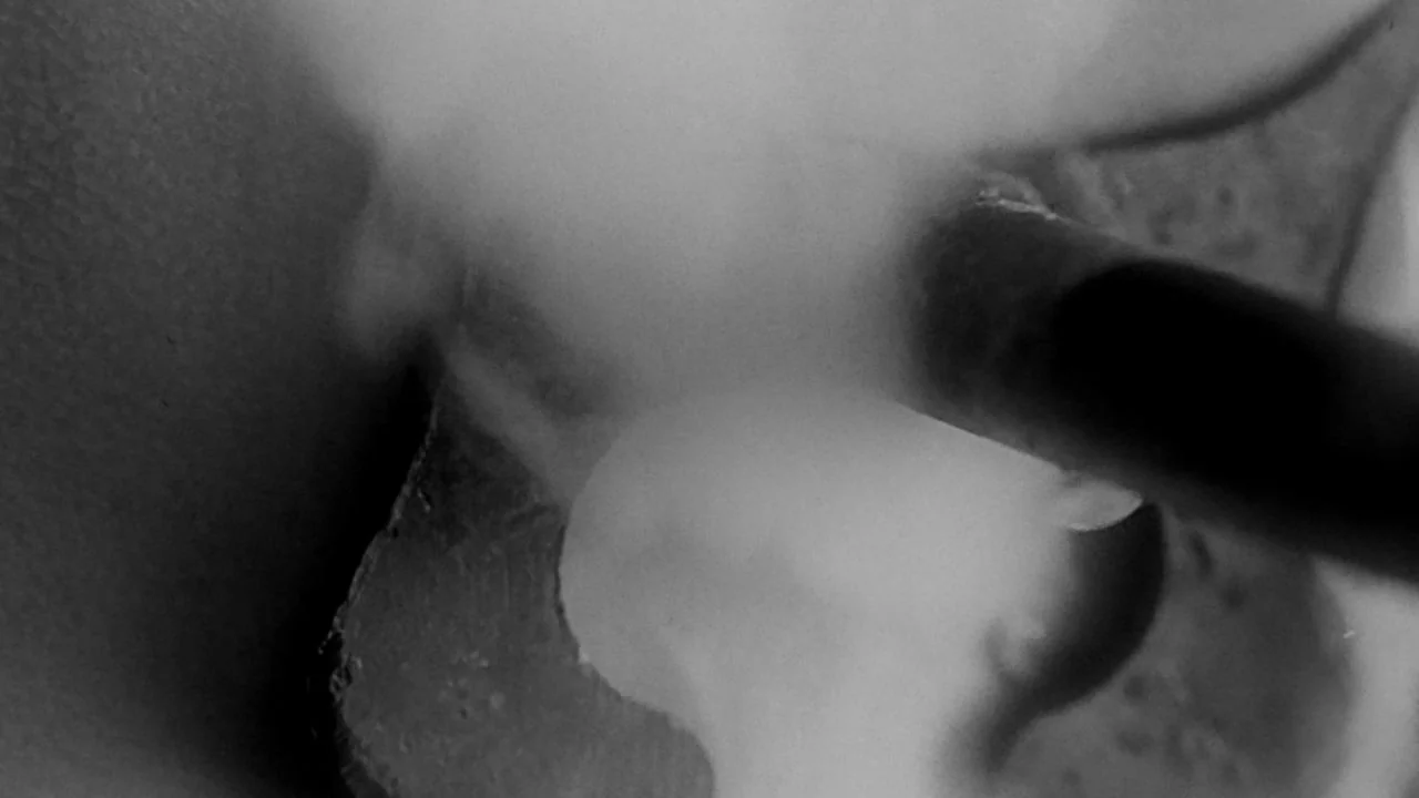 The Bride with White Hair II (1993) movie still: closeup — An abstract close-up shot focuses on a dark, rounded object positioned over a bright…