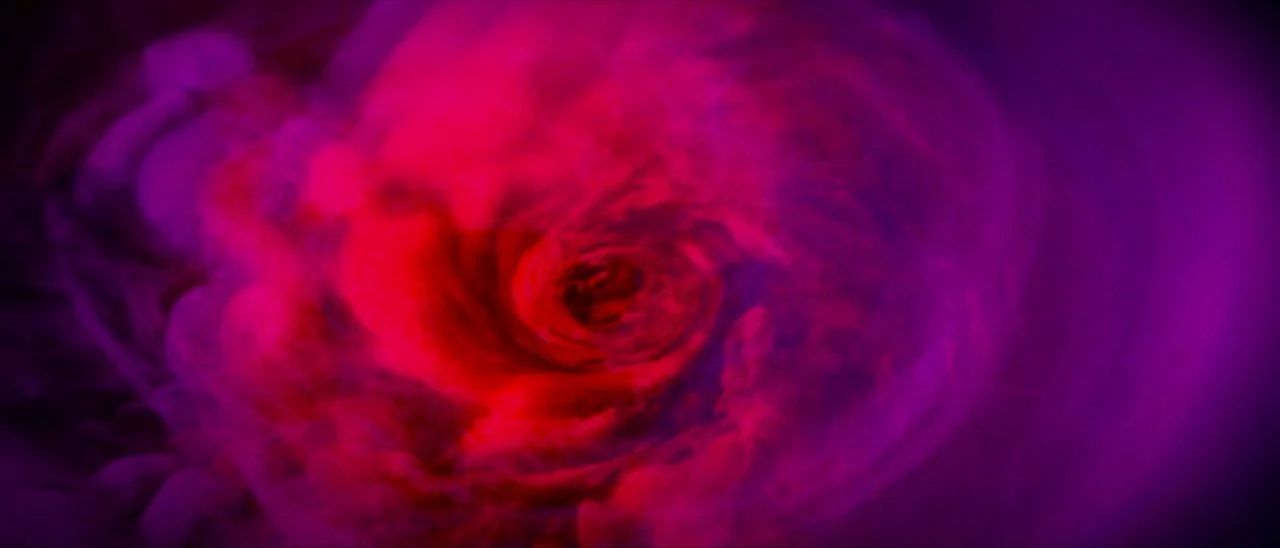 Archenemy (2020) movie still: establishing — A field of vibrant red and purple smoke swirls into a central vortex. The composition consists entirely…