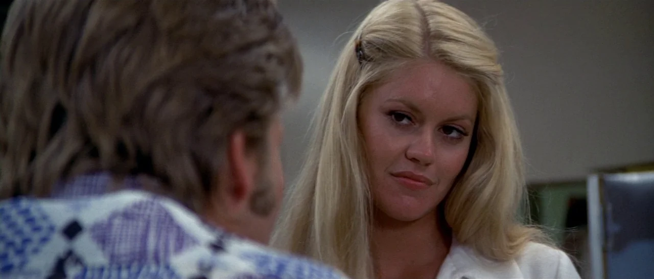 Thunderbolt & Lightfoot (1974) movie still: closeup — An interior space provides the setting for a conversation between two people. A blonde woman…