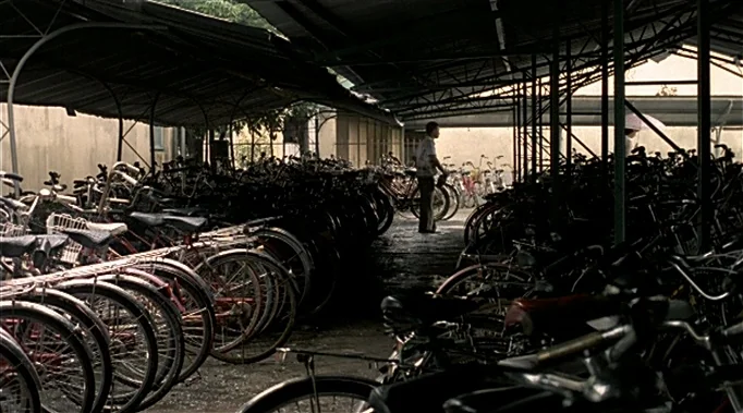 A Time To Love and A Time To Die (1985) movie still: wide — A dense parking area covered by a corrugated metal roof filled with numerous bicycles. A…