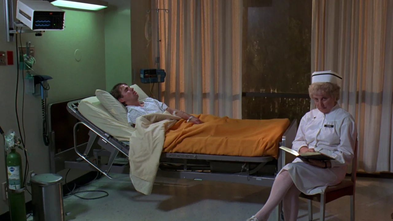 Friday the 13th: A New Beginning (1985) movie still: wide — A hospital room contains a patient bed with an orange blanket and a bedside chair. A…
