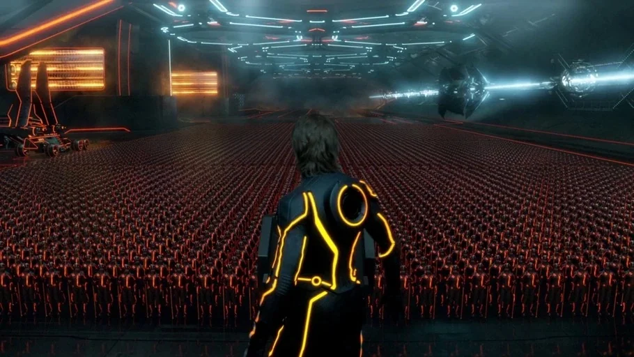TRON: Legacy (2010) movie still: medium — A vast, dark hangar houses thousands of identical soldiers in neon-lit armor. A lone figure in a matching…