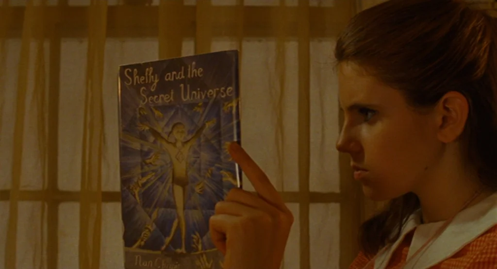 Moonrise Kingdom (2012) movie still: medium — An interior space features a window covered by sheer, warm-toned curtains in daylight. A young woman…