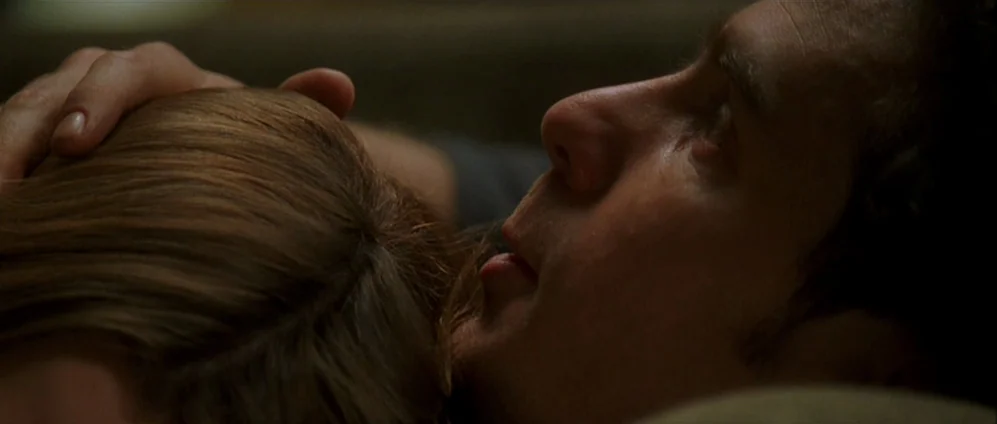 Confessions of a Dangerous Mind (2002) movie still: closeup — A dimly lit, shadowed space showing the faces of two people in close proximity. A man…