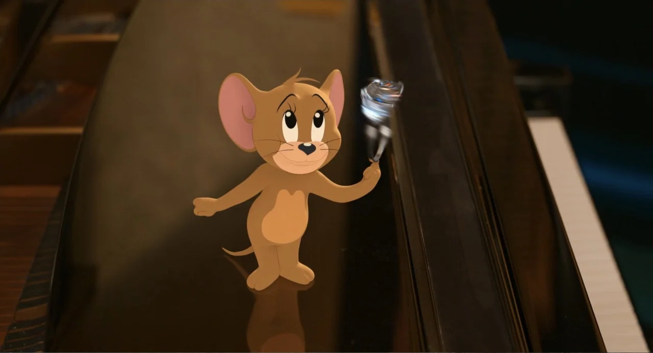 Tom & Jerry (2021) movie still: medium — A small cartoon mouse stands on the glossy, black surface of a grand piano. The mouse balances a spinning…