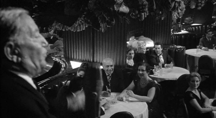 Raging Bull (1980) movie still: medium — A crowded mid-century nightclub with round tables and dark, tufted booth seating. Patrons in evening wear…