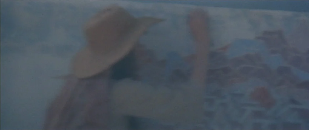 3 Women (1977) movie still: medium — A person stands before a large canvas in a hazy, softly lit environment. They reach out with one hand to paint…