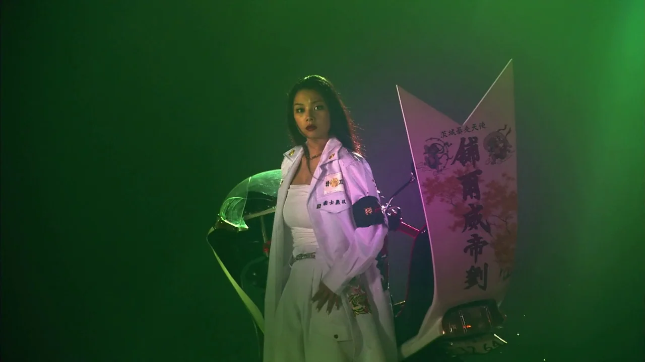 Kamikaze Girls (2004) movie still: fullbody — A woman stands in front of a white motorcycle decorated with large custom fairings. Green smoke or…