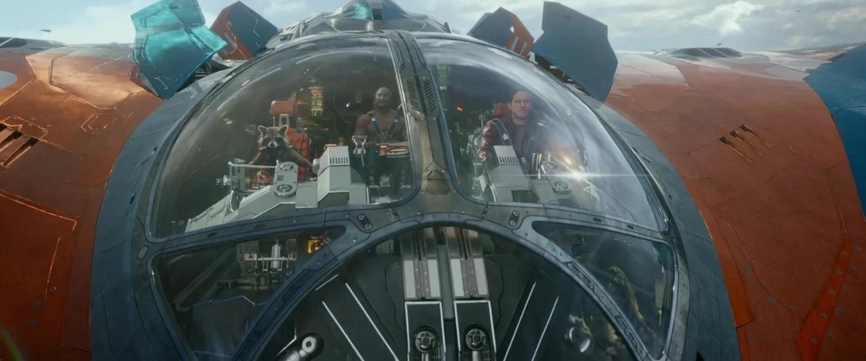Guardians of the Galaxy (2014) movie still: wide — A high-tech spacecraft flies through the sky under cloudy conditions. Three pilots sit behind the…