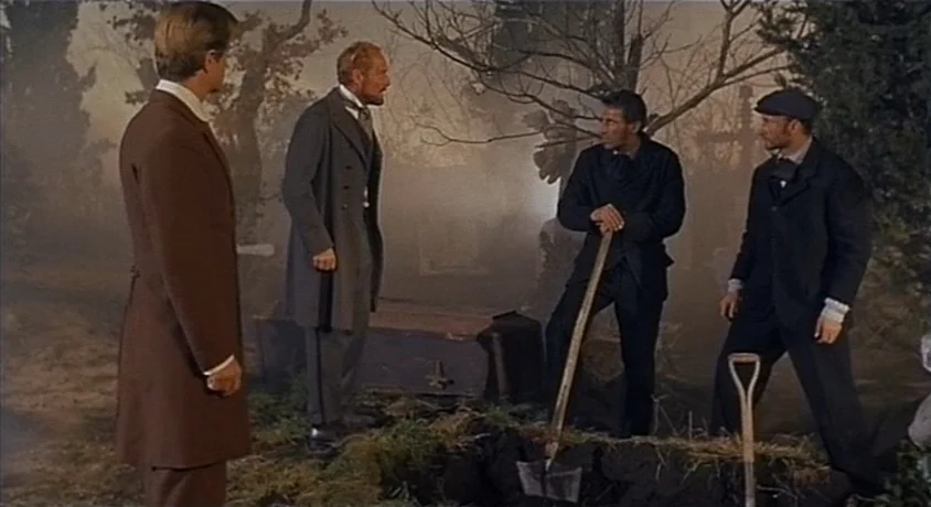 Kill, Baby Kill (1966) movie still: fullbody — A foggy, mist-filled cemetery at midday contains several gravestones and bare trees. Four men in…