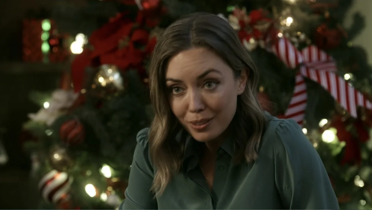 Peppermint and Postcards (2023) movie still: medium — A decorated Christmas tree with out-of-focus lights serves as the background for an interior…