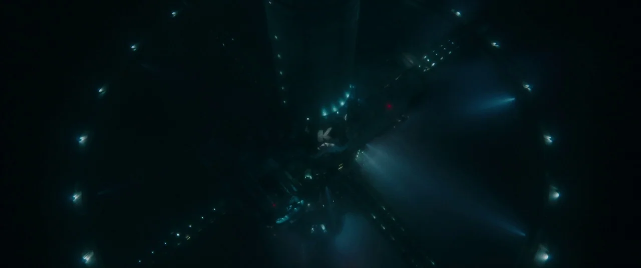 Underwater (2020) movie still: establishing — A massive circular space station is seen from directly above against a dark background. The structure…