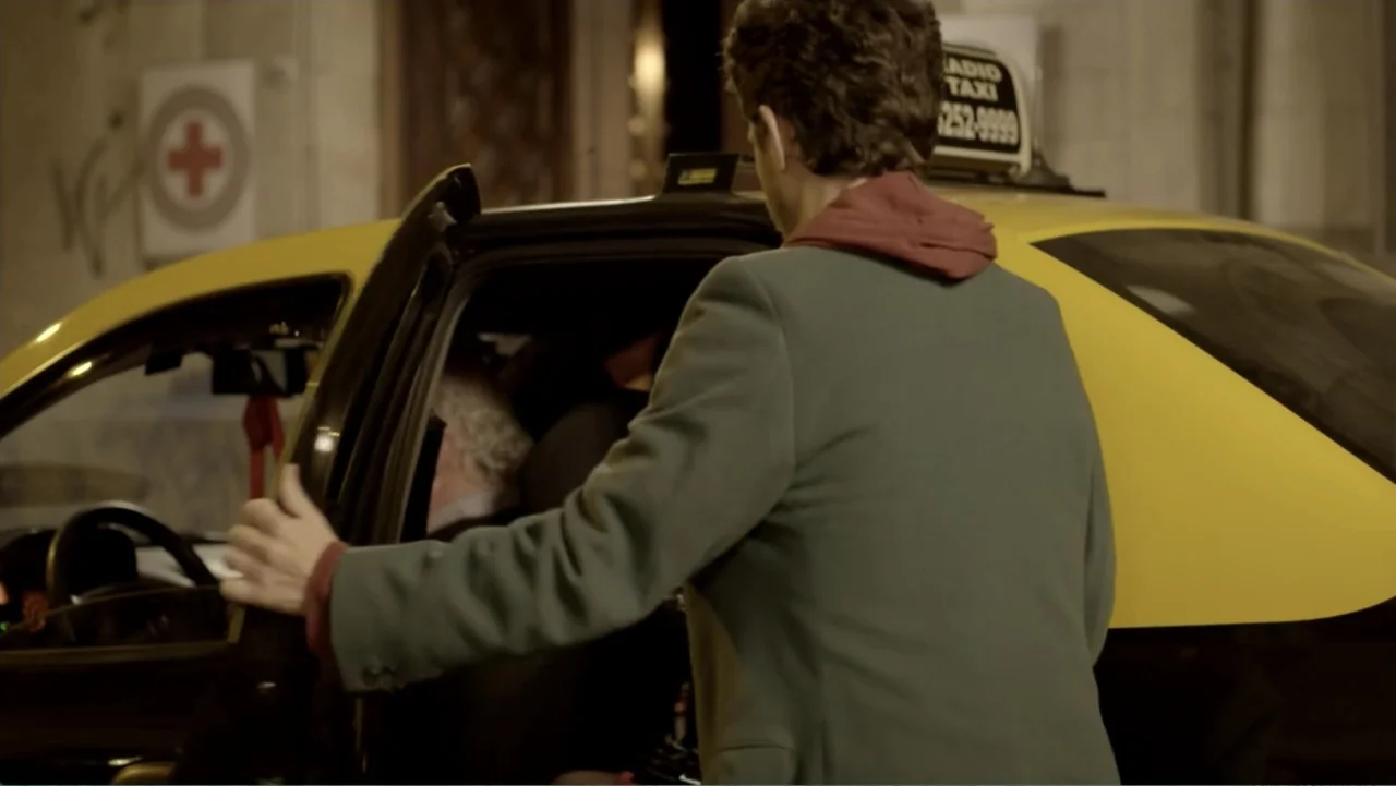 Heaven Sent (1994) movie still: medium — A city street at night featuring a yellow taxi cab parked near a building. A man wearing a grey jacket…